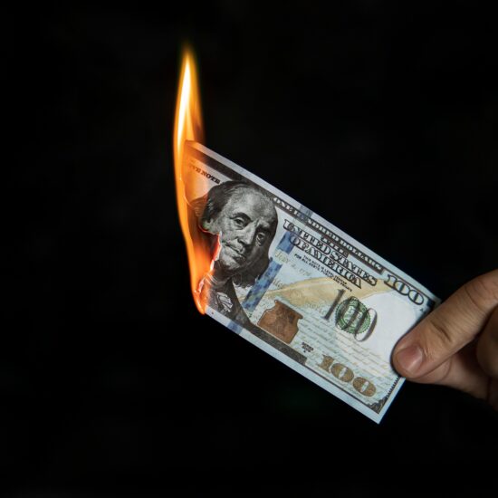 Human,Hand,Holding,A,Burning,100,Dollar,Bill.,Concept,Of
